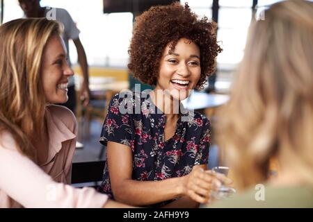 Three Young Female Friends Meeting For Drinks And Food Making A Toast In Restaurant Stock Photo
