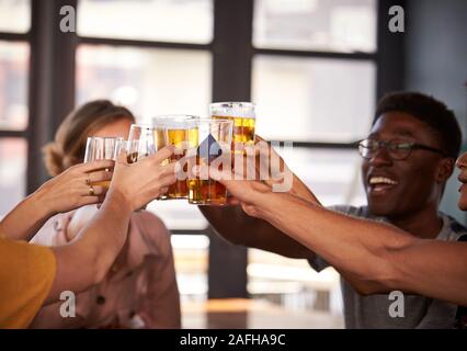 Group Of Young Friends Meeting For Drinks And Making A Toast In Restaurant Stock Photo
