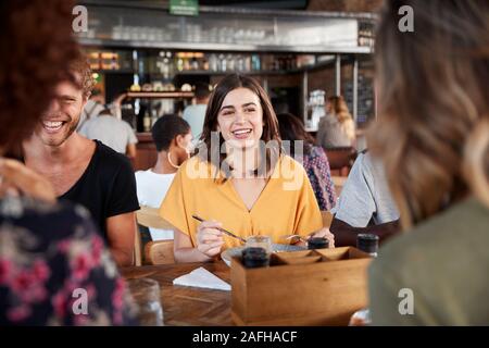 Group Of Young Friends Meeting For Drinks And Food In Restaurant Stock Photo