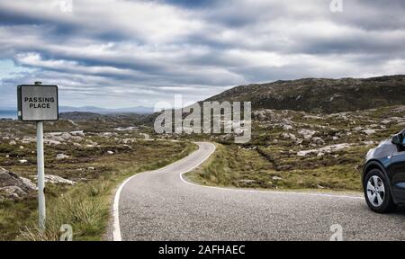 Car stopped in passing place on remote single track road amongst barren scenery on the Isle of Lewis and Harris, Outer Hebrides, Scotland Stock Photo