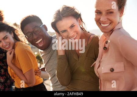 Portrait Of Smiling Young Friends Walking Outdoors Together Stock Photo