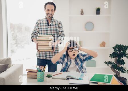 I want to have weekend concept. Photo of sad upset surprised crazy little guy touching head hate studying sitting at table and his dad prepared him Stock Photo