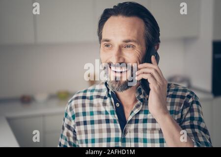 Close up photo portrait of satisfied cheerful optimistic man with modern hairstyle using cellular talking to his best fellow Stock Photo