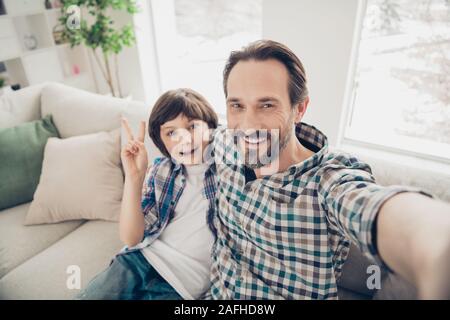 Closeup photo picture image of two handsome charming positive carefree relaxed having rest spare time together people taking selfie on modern camera Stock Photo