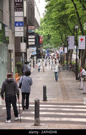 TOKYO, JAPAN - MAY 9, 2012: People shop in Omotesando district in Tokyo. Omotesando is considered one of most important shopping areas in Tokyo, the l Stock Photo