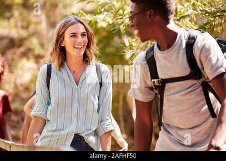Happy mixed race millennial couple hiking in a forest together, waist up, close up Stock Photo