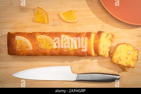 Orange cake and slices top view on wooden background Stock Photo