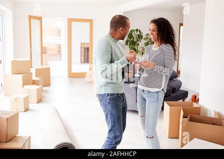 Couple Celebrating Moving Into New Home Opening Champagne Stock Photo