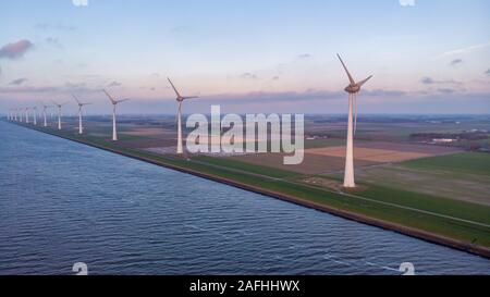 Windmill park green energy during sunset in the ocean, offshore wind mill turbines Netherlands Stock Photo