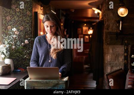 Female Receptionist Working On Laptop At Hotel Check In Stock Photo