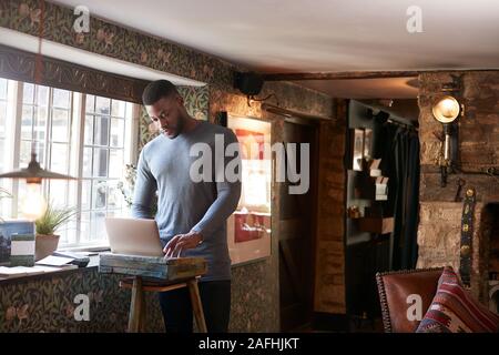 Male Receptionist Working On Laptop At Hotel Check In Stock Photo