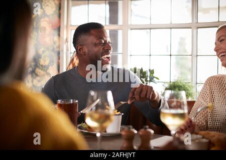 Group Of Friends Meeting For Meal In Traditional English Pub Stock Photo