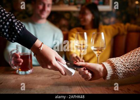 Close Up Of Customer Paying In Hotel Restaurant Using Contactless Card Reader Stock Photo