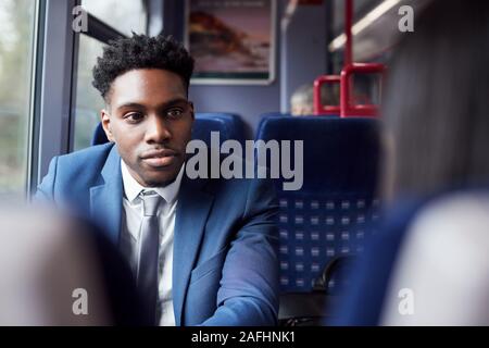 Business Passengers Sitting In Train Commuting To Work Having Discussion Stock Photo