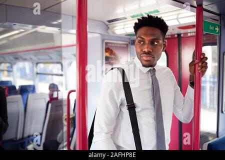Businessman Standing In Train Commuting To Work