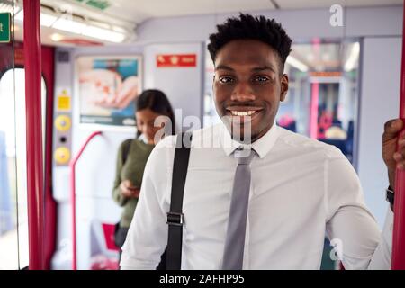 Portrait Of Smiling Businessman Standing In Train Commuting To Work Stock Photo
