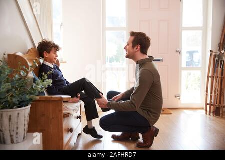 Single Father At Home Getting Son Wearing Uniform Ready For First Day Of School Stock Photo