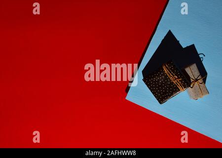 Gift boxes tied with craft cord on a two-color blue red background. Hard shadows of harsh light. Place for text Stock Photo