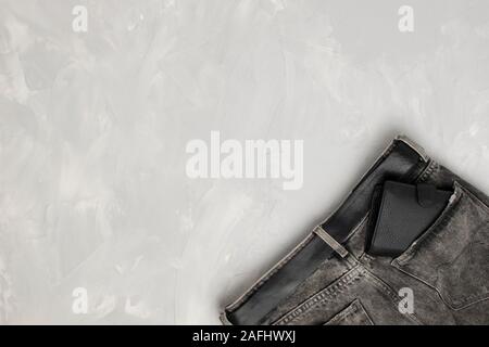 leather black wallet in a pocket of gray jeans on a white background. View from above. Place for text Stock Photo