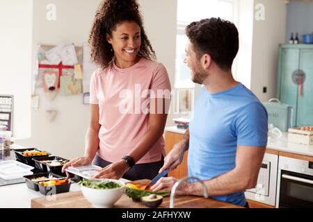 Couple Preparing Batch Of Healthy Meals At Home In Kitchen Together Stock Photo