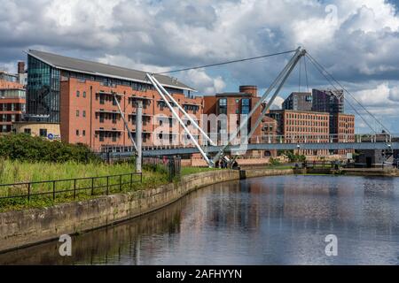 LEEDS, UNITED KINGDOM - AUGUST 13: Riverside city buildings and bridge near the Leeds dock along the River Aire on August 13, 2019 in Leeds Stock Photo
