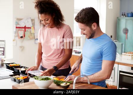 Couple Preparing Batch Of Healthy Meals At Home In Kitchen Together Stock Photo