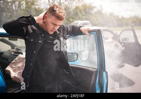 Male Motorist With Whiplash Injury In Car Crash Getting Out Of Vehicle Stock Photo