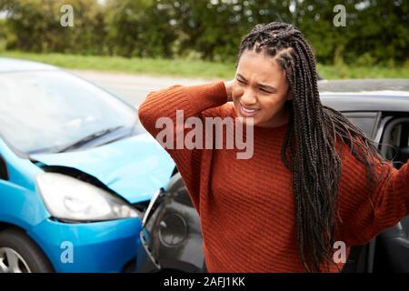 Female Motorist With Whiplash Injury In Car Crash Getting Out Of Vehicle Stock Photo