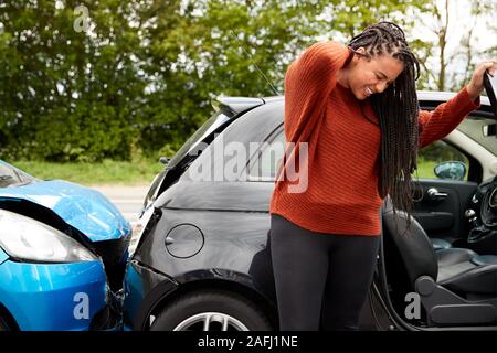 Female Motorist With Whiplash Injury In Car Crash Getting Out Of Vehicle Stock Photo