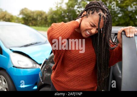 Female Motorist With Whiplash Injury In Car Crash Getting Out Of Vehicle Stock Photo