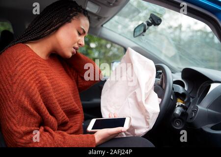 Female Motorist Injured In Car Crash After Using Mobile Phone Whilst Driving Stock Photo