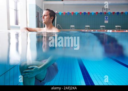 Part Underwater View Of Male Swimmer Warming Up In Swimming Pool Stock Photo