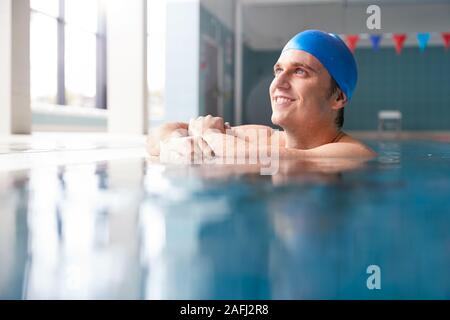 Male Swimmer Wearing Hat And Goggles Training In Swimming Pool Stock Photo