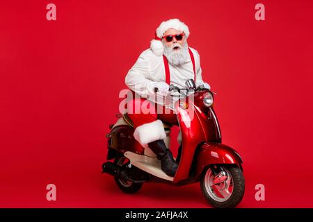 Portrait of his he nice bearded cool cheerful funky Santa hipster riding retro moped December ho-ho-ho North Pole destination isolated on bright vivid