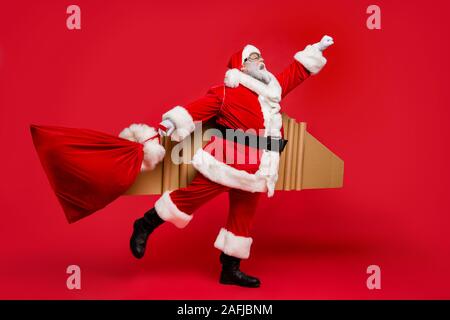 I give you wish whatever it takes. Full size photo of crazy funky smile retired space man in christmas father costume hurry fly up to deliver gifts Stock Photo