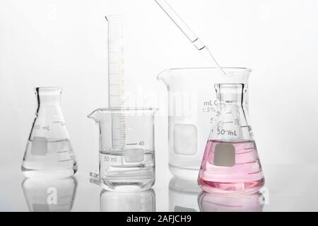 glass beaker flask cylinder and dropper with water in chemistry science laboratory white background Stock Photo