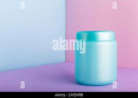 Blue plastic jar with mock up for cosmetic products on color pink background with Copy space. Cosmetic package for hair mask, conditioner shower gel h Stock Photo