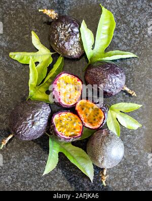 Still live composed of whole and sliced Passion fruit, Passiflora edulis, with leaves Stock Photo