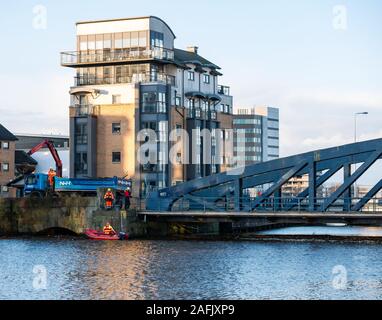 Clean up of debris and rubbish in Water of Leith river by men working from rigid hulled inflatable boat & lorry with crane, Edinburgh, Scotland, UK Stock Photo