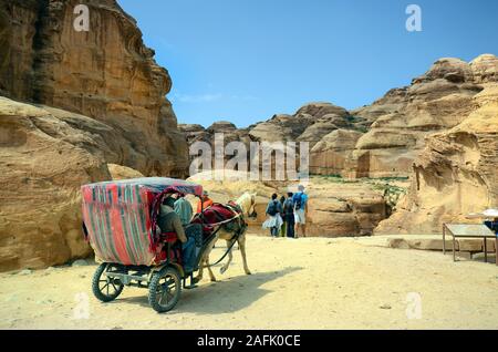 Petra, Jordan - March 06, 2019: Unidentified people in carriage and on road to ancient Petra