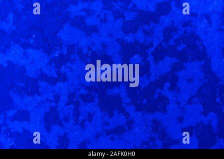 Bright abstract texture of wet plaster on the wall, saturated blue and its shades. Stock Photo