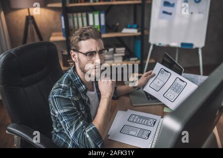 Young bearded man in eyeglasses looking thoughtful Stock Photo