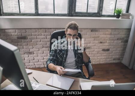 Young man in eyeglasses speaking on the phone Stock Photo