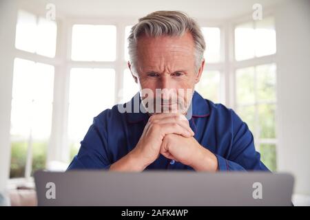 Serious Mature Man Looking Up Information Online Using Laptop Stock Photo