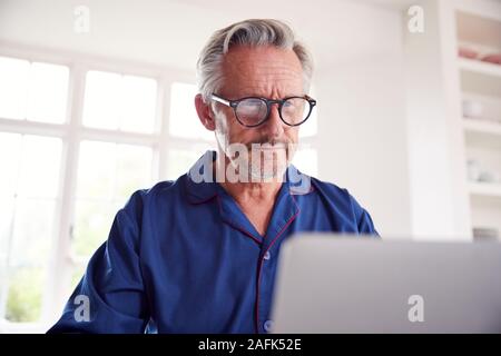 Serious Mature Man Looking Up Information Online Using Laptop Stock Photo