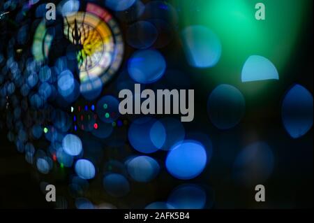 city street time concept silhouette of human in darkness among color bokeh lights with clock with face and hand Stock Photo