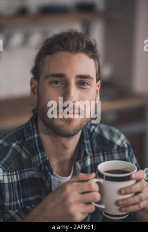 Handsome long-haired man drinking his morning coffee Stock Photo