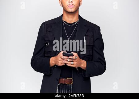 Close Up Studio Shot Of Causally Dressed Young Man Using Mobile Phone Stock Photo