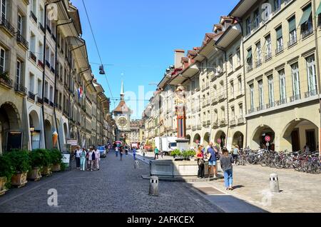 Bern, Switzerland - August 14, 2019: People walking in the old town of the Swiss capital. Famous Kramgasse with astronomical clock Zytglogge. Historical buildings, traditional fountains. Stock Photo