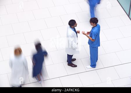 Overhead View Of Male Medical Staff Having Informal Meeting In Lobby Of Modern Hospital Building Stock Photo